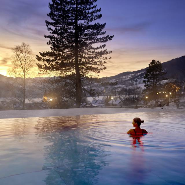 Frau in beheiztem Außenpool genießt Blick auf die Berge im Wellnesshotel im Allgäu Prinz-Luitpold-Bad